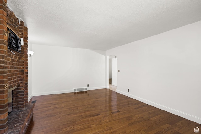 1657 E 1500 N, Logan, UT 84341 - unfurnished living room with a brick fireplace, wood finished floors, and a textured ceiling