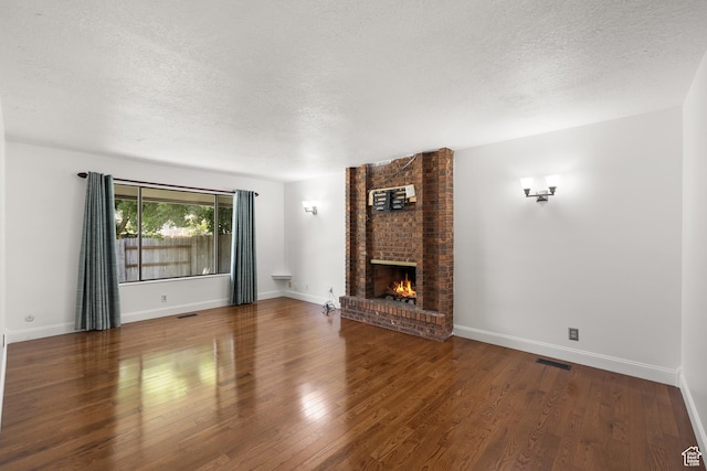 1657 E 1500 N, Logan, UT 84341 - unfurnished living room featuring a textured ceiling, a fireplace, and wood finished floors