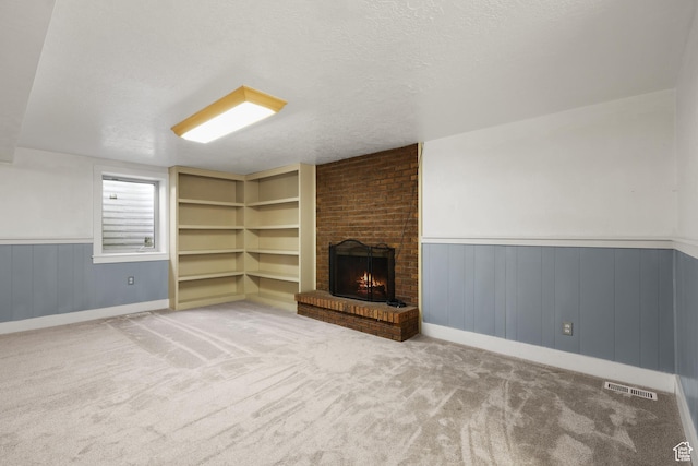 1657 E 1500 N, Logan, UT 84341 - unfurnished living room with wainscoting, a brick fireplace, carpet floors, and a textured ceiling