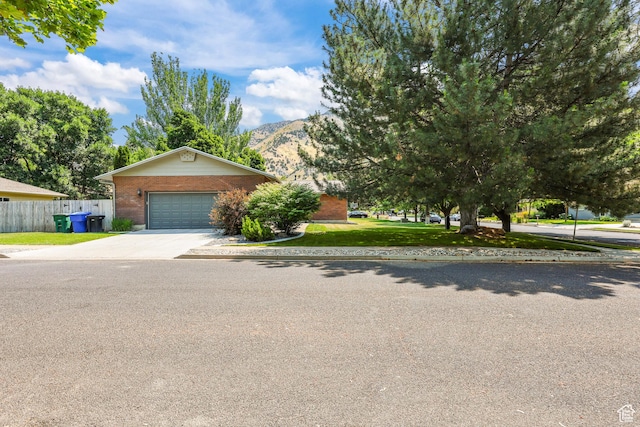 1657 E 1500 N, Logan, UT 84341 - obstructed view of property with driveway, brick siding, a mountain view, and an attached garage
