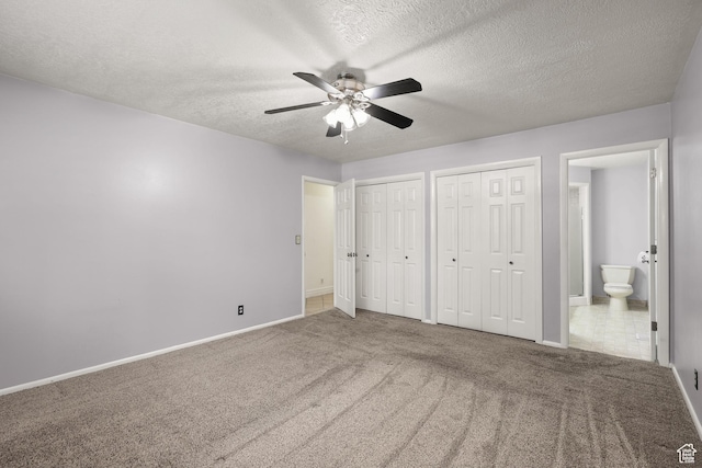 1657 E 1500 N, Logan, UT 84341 - unfurnished bedroom with two closets, carpet flooring, ensuite bath, a textured ceiling, and ceiling fan