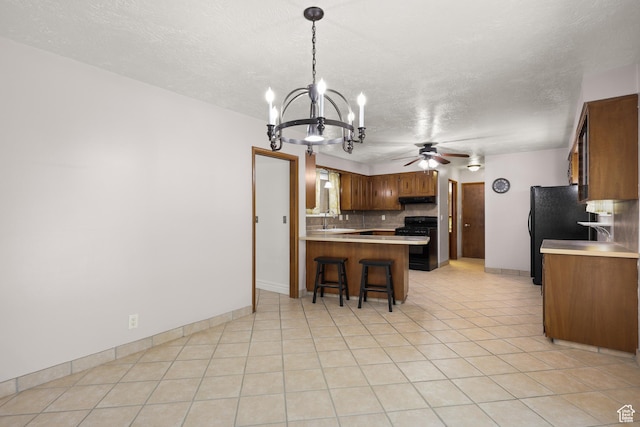 1657 E 1500 N, Logan, UT 84341 - kitchen with black appliances, a peninsula, under cabinet range hood, a chandelier, and ceiling fan