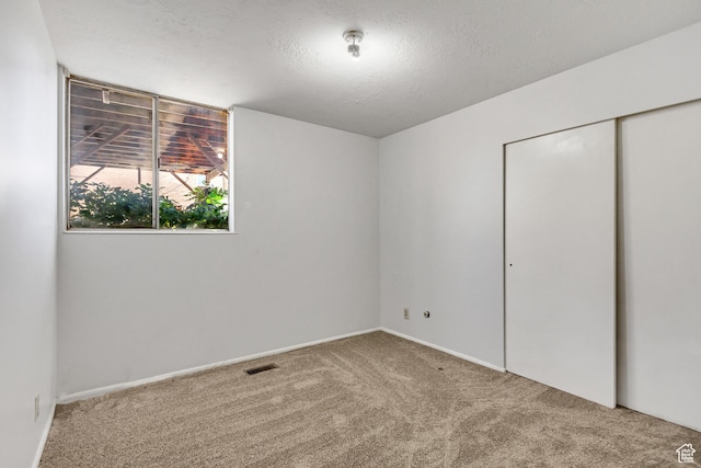 1050 Healy St Unit 1, Ogden, UT 84403 - unfurnished bedroom with carpet floors, a closet, and a textured ceiling