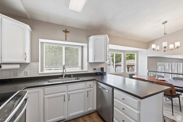 573 E Compass Cir S, North Salt Lake, UT 84054 - kitchen with stainless steel appliances, dark countertops, a peninsula, decorative backsplash, and white cabinetry