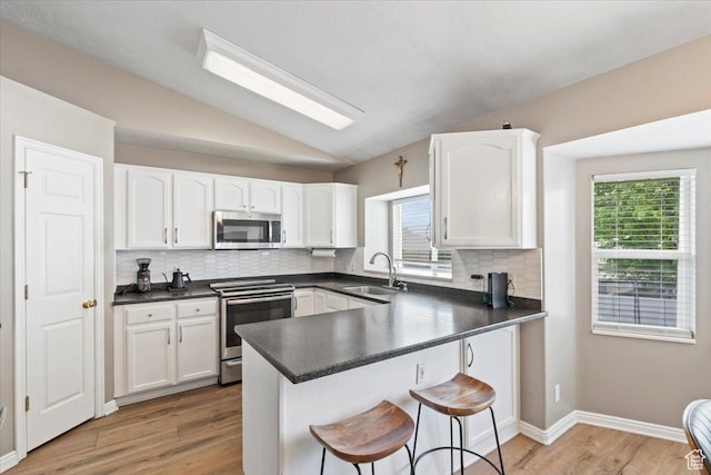 573 E Compass Cir S, North Salt Lake, UT 84054 - kitchen featuring stainless steel appliances, a kitchen breakfast bar, white cabinetry, and lofted ceiling