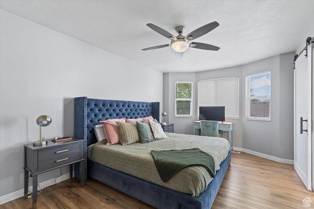 573 E Compass Cir S, North Salt Lake, UT 84054 - bedroom featuring a barn door, wood finished floors, and ceiling fan