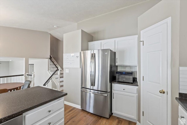 573 E Compass Cir S, North Salt Lake, UT 84054 - kitchen featuring freestanding refrigerator, dark countertops, wood finished floors, white cabinetry, and tasteful backsplash