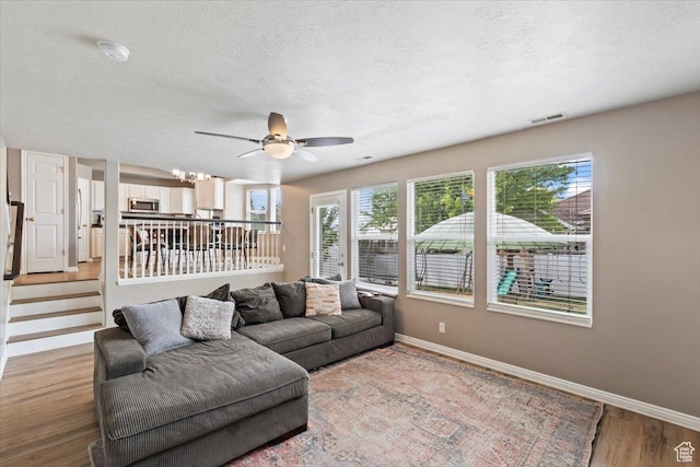 573 E Compass Cir S, North Salt Lake, UT 84054 - living room featuring light wood-type flooring, a ceiling fan, a textured ceiling, and a chandelier
