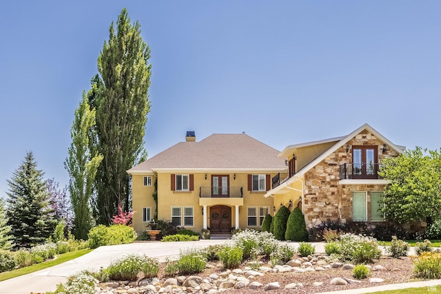 897 W Pfeifferhorn Dr, Alpine, UT 84004 - view of front facade featuring french doors, a balcony, stone siding, driveway, and stucco siding