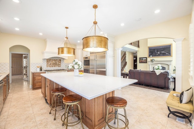 897 W Pfeifferhorn Dr, Alpine, UT 84004 - kitchen featuring appliances with stainless steel finishes, arched walkways, premium range hood, light countertops, and decorative backsplash