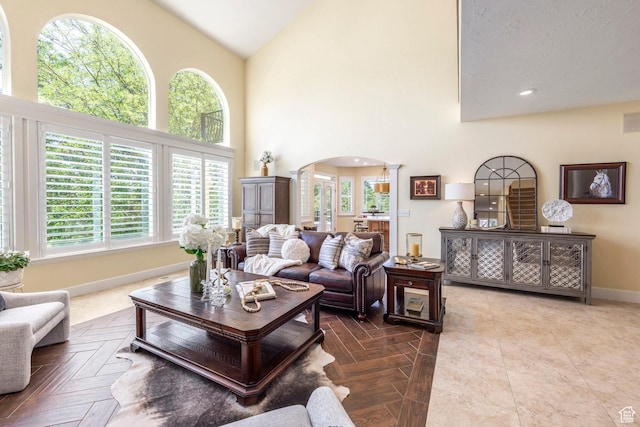 897 W Pfeifferhorn Dr, Alpine, UT 84004 - living area featuring arched walkways, decorative columns, healthy amount of natural light, and high vaulted ceiling