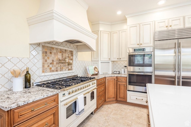 897 W Pfeifferhorn Dr, Alpine, UT 84004 - kitchen featuring high end appliances, custom range hood, brown cabinets, and light stone counters