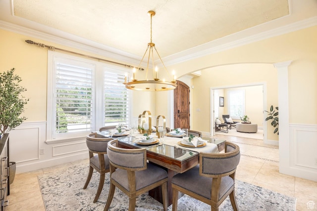 897 W Pfeifferhorn Dr, Alpine, UT 84004 - dining space with arched walkways, a chandelier, a wainscoted wall, crown molding, and light tile patterned floors