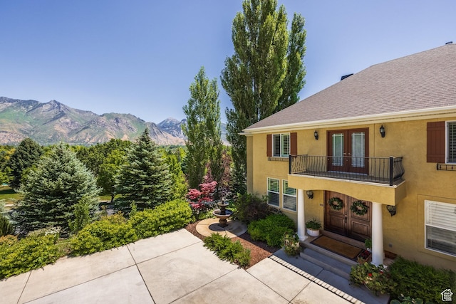 897 W Pfeifferhorn Dr, Alpine, UT 84004 - view of front facade with french doors, a balcony, stucco siding, a mountain view, and roof with shingles