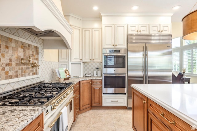 897 W Pfeifferhorn Dr, Alpine, UT 84004 - kitchen featuring premium appliances, brown cabinetry, tasteful backsplash, light stone counters, and ornamental molding