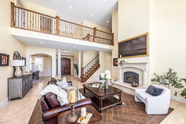 897 W Pfeifferhorn Dr, Alpine, UT 84004 - living area with arched walkways, ornate columns, a high ceiling, a glass covered fireplace, and recessed lighting
