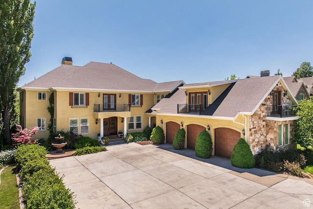 897 W Pfeifferhorn Dr, Alpine, UT 84004 - view of front of house with a balcony, french doors, a chimney, stucco siding, and driveway