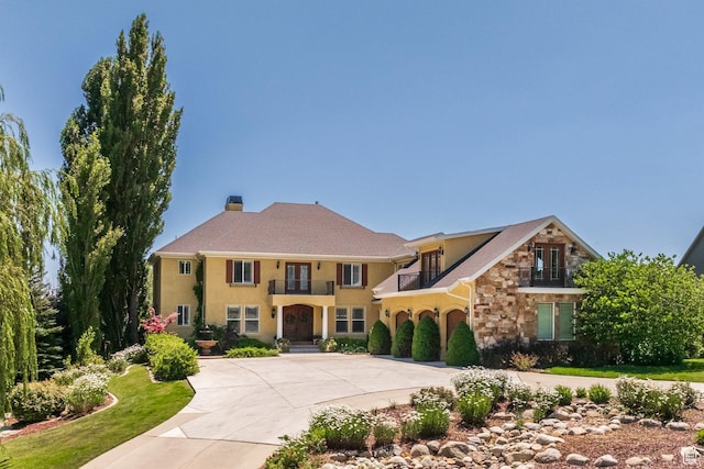 897 W Pfeifferhorn Dr, Alpine, UT 84004 - mediterranean / spanish house with a balcony, stone siding, curved driveway, stucco siding, and a chimney