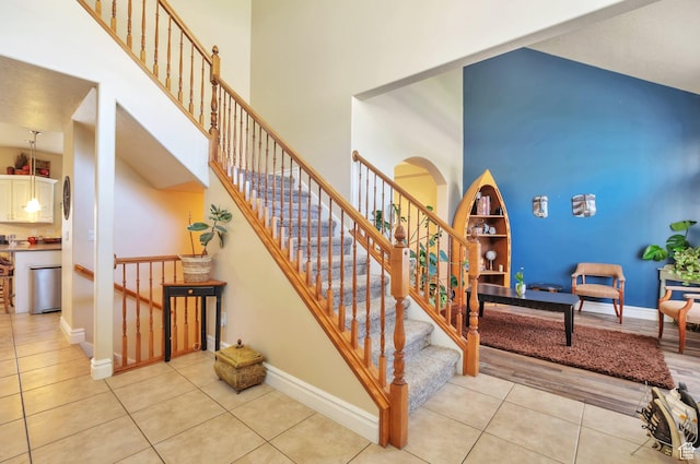 483 W 3500 N, Pleasant View, UT 84414 - staircase with tile patterned floors, a towering ceiling, and arched walkways