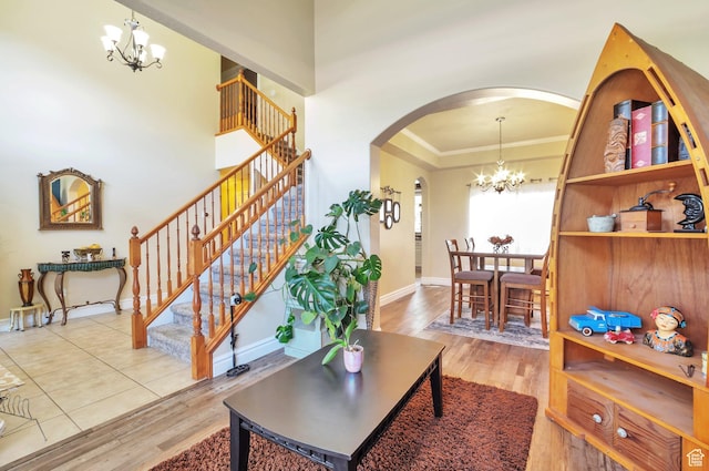 483 W 3500 N, Pleasant View, UT 84414 - living room with a chandelier, arched walkways, ornamental molding, stairs, and wood finished floors