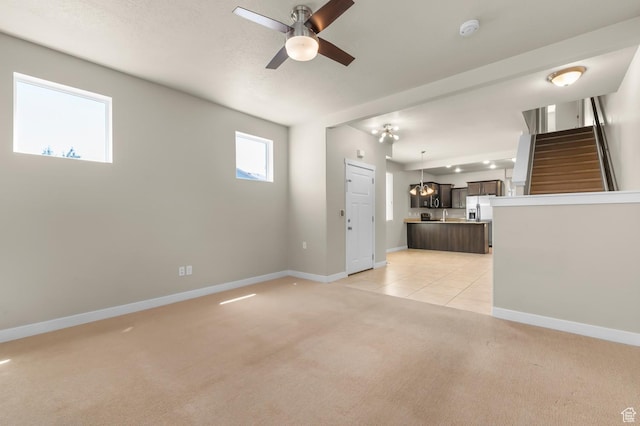 1012 W Willow Wind Dr, Farmington, UT 84025 - unfurnished living room with light carpet, a ceiling fan, and stairs