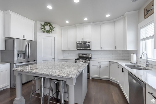 2460 N 2825 W, Plain City, UT 84404 - kitchen featuring stainless steel appliances, a breakfast bar area, white cabinets, dark wood-type flooring, and tasteful backsplash