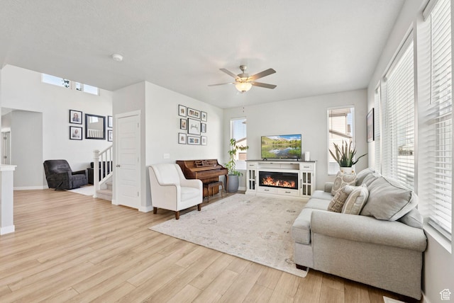 1346 W 1250 S, Springville, UT 84663 - living area featuring wood finished floors, stairs, ceiling fan, a glass covered fireplace, and healthy amount of natural light