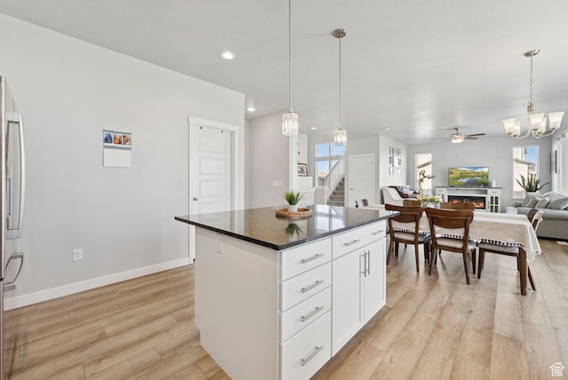 1346 W 1250 S, Springville, UT 84663 - kitchen with light wood-style floors, open floor plan, a kitchen island, a ceiling fan, and white cabinets