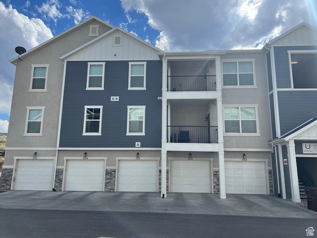 14652 S Astin Ln Unit U102, Herriman, UT 84096 - rear view of property featuring board and batten siding, stucco siding, a garage, and stone siding
