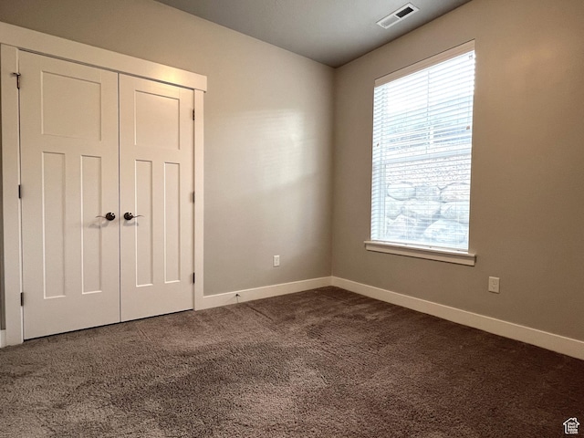 14652 S Astin Ln Unit U102, Herriman, UT 84096 - unfurnished bedroom with multiple windows, dark colored carpet, and a closet