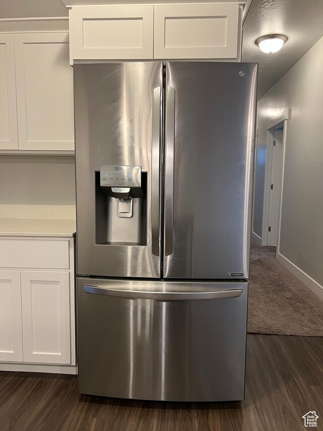 14652 S Astin Ln Unit U102, Herriman, UT 84096 - detailed view of stainless steel fridge with ice dispenser, white cabinets, dark wood-style floors, and light countertops