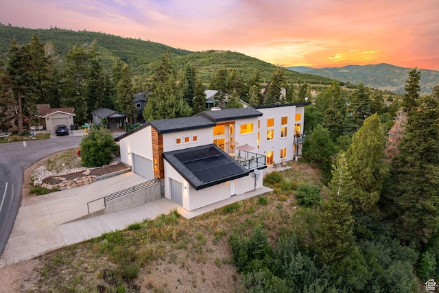 249 S Parkview Dr E, Park City, UT 84098 - rear view of property featuring stucco siding, concrete driveway, a mountain view, a garage, and a balcony