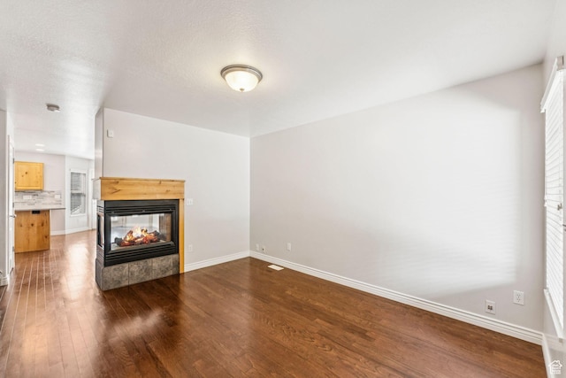 631 E Clearwater Dr, Layton, UT 84041 - unfurnished living room featuring hardwood / wood-style floors, a multi sided fireplace, and healthy amount of natural light