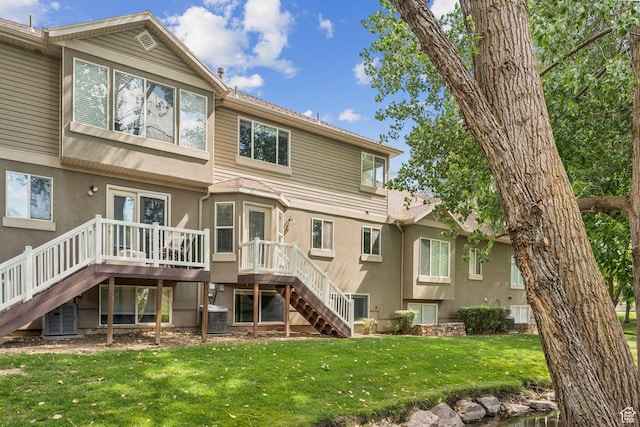 631 E Clearwater Dr, Layton, UT 84041 - back of property with stairway, a wooden deck, stucco siding, and a lawn