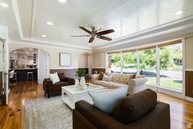 2400 E Logan Way S, Salt Lake City, UT 84108 - living area featuring arched walkways, wainscoting, ceiling fan, wood finished floors, and crown molding