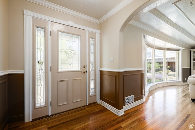 2400 E Logan Way S, Salt Lake City, UT 84108 - entryway featuring arched walkways, wood finished floors, ornamental molding, a decorative wall, and a wainscoted wall