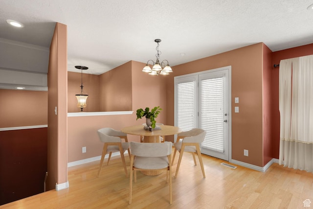 1339 Alpine Way, Provo, UT 84606 - dining area featuring light wood-type flooring, a chandelier, and a textured ceiling