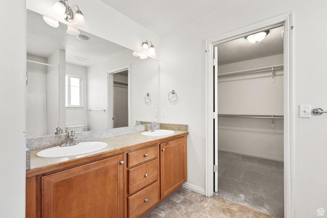 1339 Alpine Way, Provo, UT 84606 - bathroom with double vanity, a spacious closet, a textured ceiling, and a shower