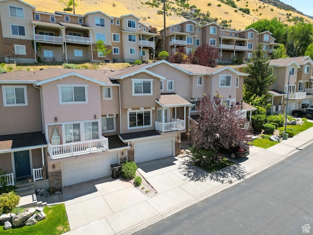 1339 Alpine Way, Provo, UT 84606 - view of front facade with a residential view, a garage, stone siding, a mountain view, and driveway