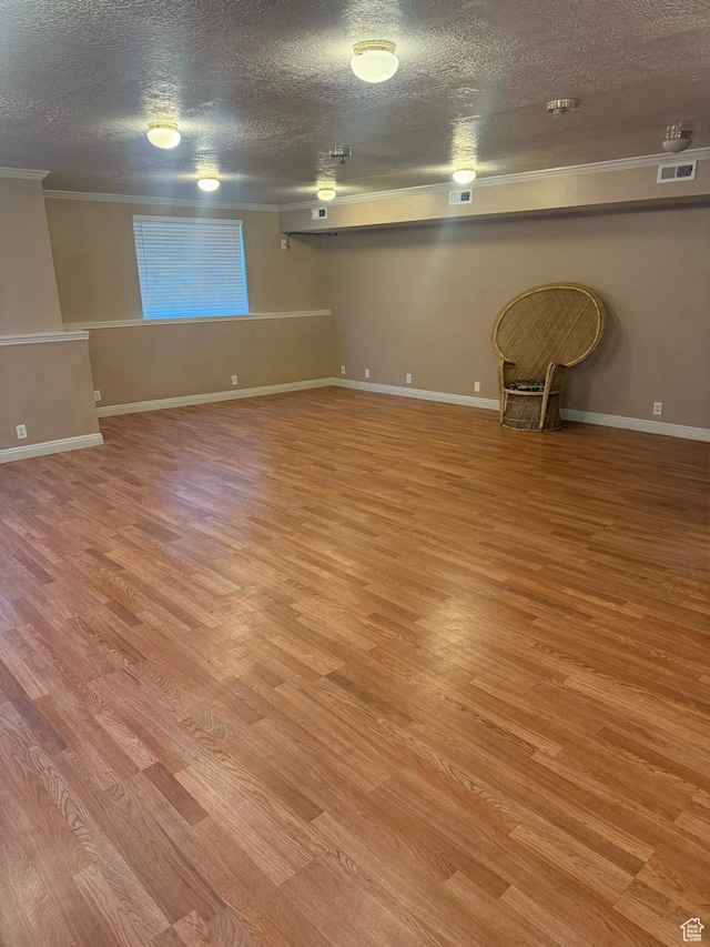 8048 W Copperfield Pl # 31, Magna, UT 84044 - unfurnished living room featuring crown molding, a textured ceiling, and light wood-style floors