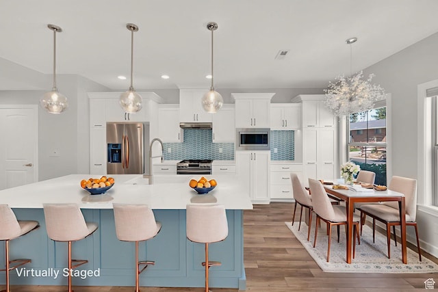 960 E 6740 S, Midvale, UT 84047 - kitchen featuring appliances with stainless steel finishes, wood finished floors, backsplash, white cabinets, and recessed lighting