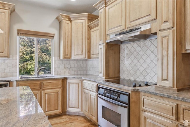 5588 S Farm Hill Dr, Salt Lake City, UT 84117 - kitchen with stainless steel oven, under cabinet range hood, black electric stovetop, decorative backsplash, and light brown cabinetry