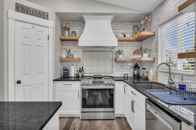 5548 S 3850 W, Roy, UT 84067 - kitchen featuring open shelves, appliances with stainless steel finishes, premium range hood, decorative backsplash, and dark stone counters