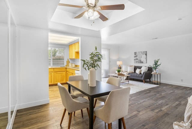 5704 S Waterbury Way Unit H, Murray, UT 84121 - dining room featuring a tray ceiling, hardwood / wood-style floors, and a ceiling fan