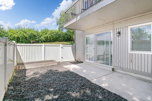 5704 S Waterbury Way Unit H, Murray, UT 84121 - fenced backyard featuring a balcony, a gate, and a patio area