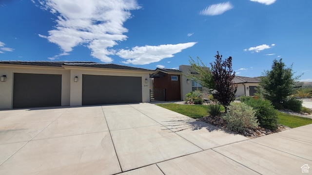 3040 E Lavatera Dr S, St George, UT 84790 - view of front of home featuring concrete driveway, an attached garage, stucco siding, and a tile roof