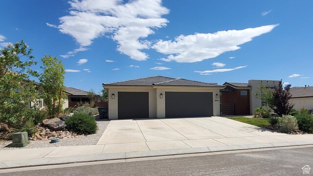3040 E Lavatera Dr S, St George, UT 84790 - view of front of home with an attached garage, concrete driveway, stucco siding, and a tile roof