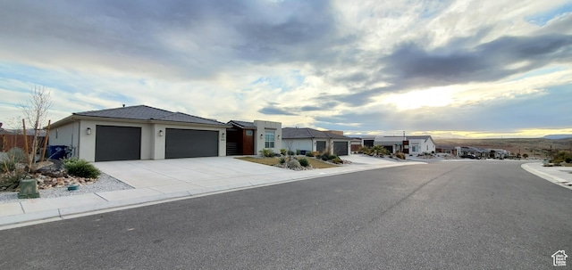 3040 E Lavatera Dr S, St George, UT 84790 - view of front of home featuring an attached garage, concrete driveway, stucco siding, and a residential view