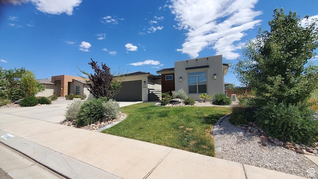 3040 E Lavatera Dr S, St George, UT 84790 - view of front of house with concrete driveway, a garage, stucco siding, and a front lawn