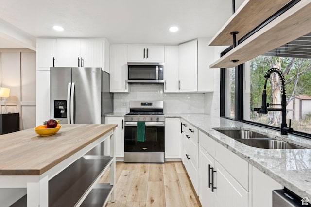 1043 S 1300 W, Salt Lake City, UT 84104 - kitchen with appliances with stainless steel finishes, wood counters, tasteful backsplash, light wood finished floors, and recessed lighting